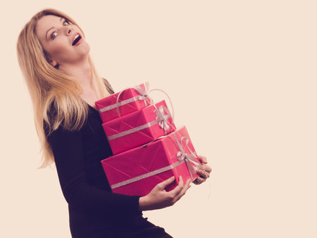 People celebrating xmas love and happiness concept. Funny blonde girl carrying presents stack of...