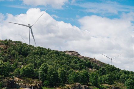 Power generators farm on rocky coast hills, wind turbines in Norway. Renewable eco energy concept.