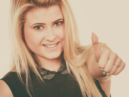 Positive gestures, success and innovations concept. Smiling blonde woman making thumb up gestureの写真素材