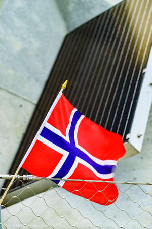 Norwegian flag waving outdoor against solar panelsの写真素材