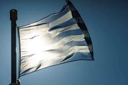 Close up of blue nad white Greek flag waving on wind. National landmark concept.の写真素材