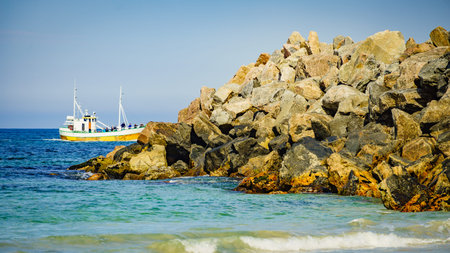 Seascape with fishing boat and stone breakwater, Bleik village, Andoya island, Vesteralen...