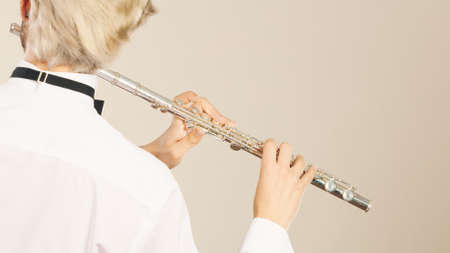 Flute music playing professional male flutist musician performer. Young elegant stylish man with instrumentの写真素材