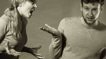 Negative emotions concept. People in fight. Husband and wife arguing and yelling on each other. Expressive and emotional couple having argument.の写真素材