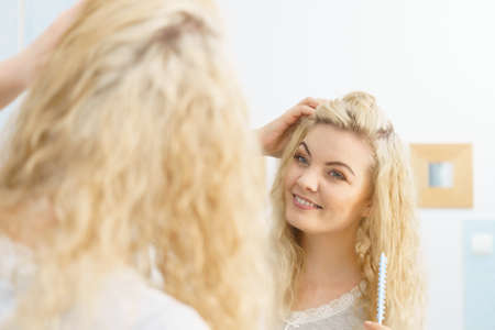 Happy woman having wet blonde hair. Positive clean female after taking a shower feeling clean and relaxed.の写真素材