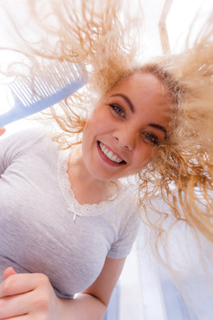 Happy woman having wet blonde hair. Positive clean female after taking a shower feeling clean and...