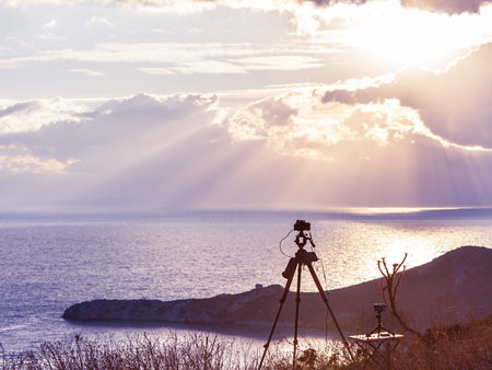 Professional camera taking picture film video of sunrise over sea surface, Greece Peloponnese Mani...
