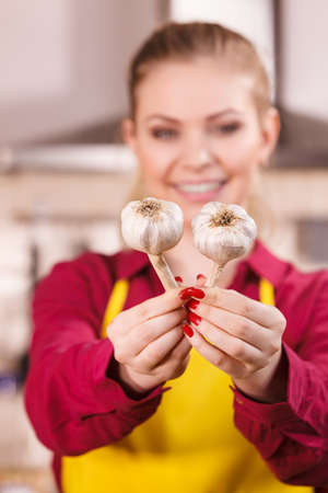 Woman holding healthy herb, two fresh natural garlic. Healthy eating and dieting concept.の写真素材