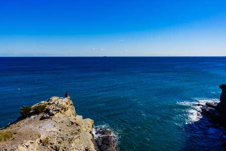 Tourist woman on Spanish rocky coastline in Murcia region. Mediterranean Sea coast landscape, Calblanque Regional Park.の写真素材