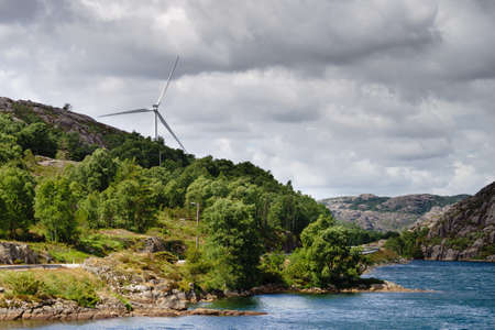 Power generators farm on rocky coast hills, wind turbines in Norway. Renewable eco energy concept.の写真素材