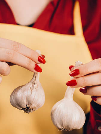 Woman holding healthy herb, two fresh natural garlic. Healthy eating and dieting concept.の写真素材
