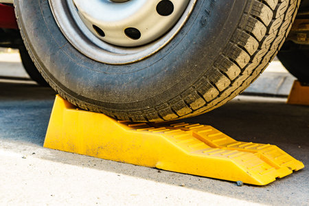 Camper leveling yellow block in use. Leveler ramp chock blocks for rv travel trailer. Accessories...