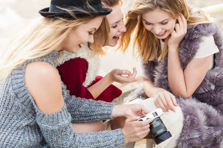 Female photographer showing fashion models results of photo shoot. Behind the scenes of professional modeling and photography industry.の写真素材