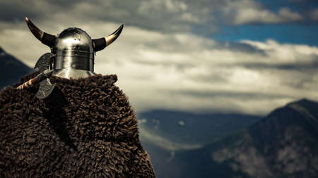 Viking warrior with helmet and axe on fjord shore in Norway. Tourism and traveling conceptの写真素材