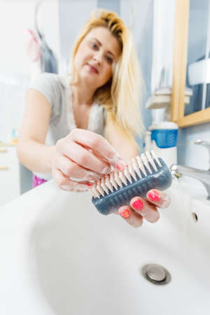 Woman washing her hands in sink to get rid of dirt using brush. Personal hygiene concept.の写真素材