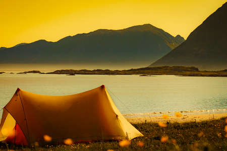 Tent on beach seashore in summer. Camping on ocean shore. Lofoten archipelago Norway. Holidays and travel.の写真素材