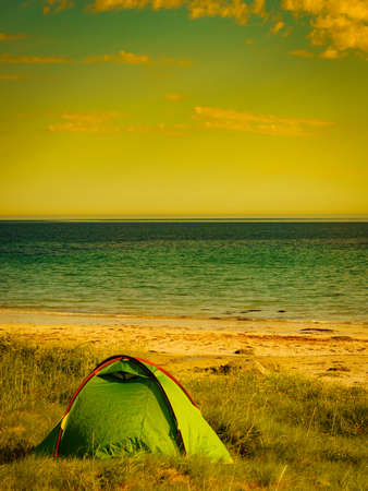 Tent on beach seashore in summer. Camping on ocean shore. Lofoten archipelago Norway. Holidays and travel.の写真素材