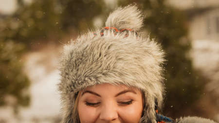 Pretty young woman wearing warm accessories during winter time. Female having grey warm hat made of light furの写真素材