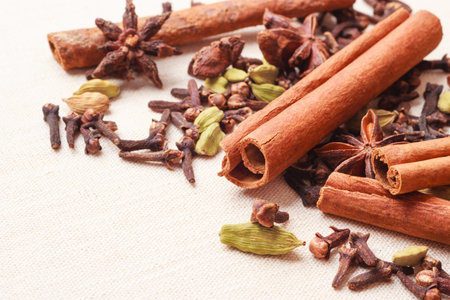 Spices for christmas cakes cinnamon sticks anise stars and cloves on burlap background
