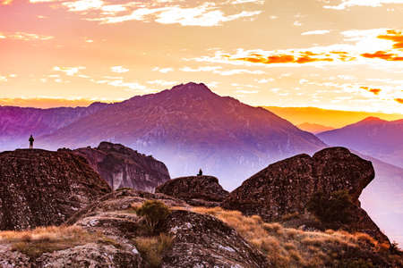 Tourists in mountains at sunset, two persons on cliffs rocky formations in Thessaly Greece. Tourism vacation and travel.の写真素材