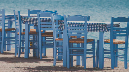 Seaside blue table and chairs open cafe outdoor restaurant in Greece on sea shore. Summer vacation on resort.の写真素材