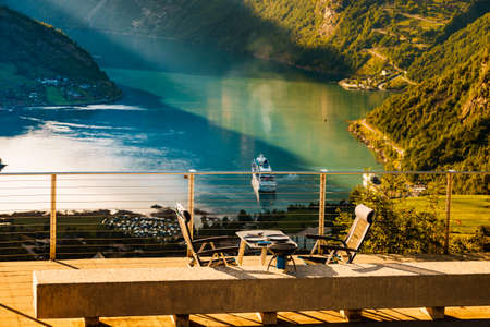 Dinner table with grill outdoor in norwegian mountains with view over Geiranger fjord. Traveling, camping on nature.の写真素材