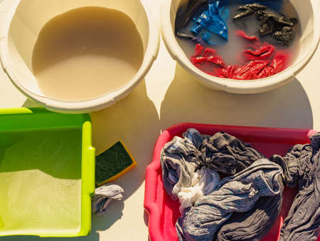 Soak clothes before washing outdoors. Bowl with soap water and laundry. Camping on nature.の写真素材