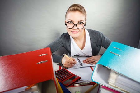 Paperwork administration bureau clerk concept. Young happy secretary at work. Office lady doing her job.の写真素材