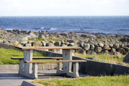 Picnic site rest stop area wooden chairs and table on norwegian sea shore. Holidays relaxation on trip. Scandinavia Europe.の写真素材