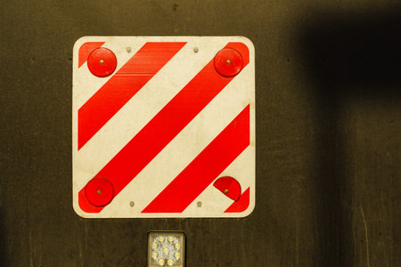 Rear warning striped sign white and red for safety on back of large trailer.