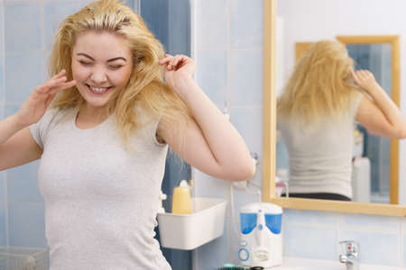 Happy young blonde woman after waking up in bathroom. Female feeling great fresh and clean.の写真素材