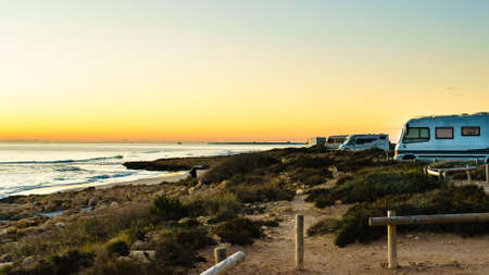 Camping on sea beach. Spanish Costa Blanca coastline with camper cars, Spain Alicante province.の写真素材