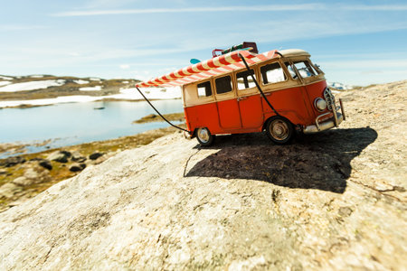 SOGNEFJELLET, NORWAY - JULY 7, 2018: Miniature scale model hippy VW van in norwegian mountains,...