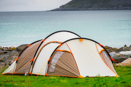 Tent on seashore in summer, cloudy hazy weather. Camping on ocean shore. Skagsanden Beach Flakstadoy...