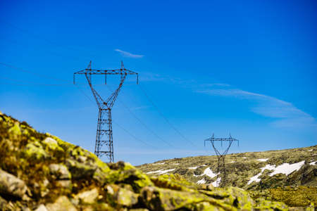Electricity transmission pylons, power lines high voltage towers in norwegian mountains landscape.の写真素材