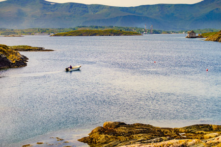 ATLANTIC ROAD, NORWAY - July 11, 2018: Angler in fishing boat on sea, Atlantic road in Norway Europe. Norwegian national scenic route. Tourist attraction.のeditorial素材