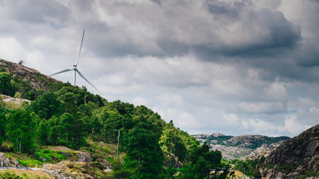 Power generators farm on rocky coast hills, wind turbines in Norway. Renewable eco energy concept.