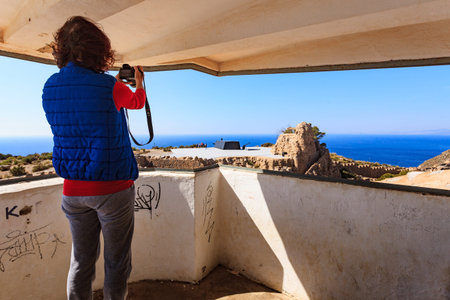 Tourist attraction. Woman with camera taking travel picture at Battery de Castillitos in Spain...