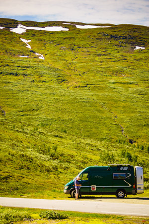 Tourism vacation and travel. Male tourist at camper van in summer mountains. National tourist route Aurlandsfjellet.の写真素材