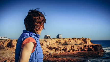 Tourist woman on spanish rocky coastline., windy day. Torrevieja, Costa Blanca, province of Alicante.の写真素材