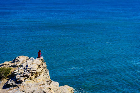 Tourist woman on spanish rocky coastline in Murcia region. Mediterranean Sea coast landscape, Calblanque Regional Park.の写真素材