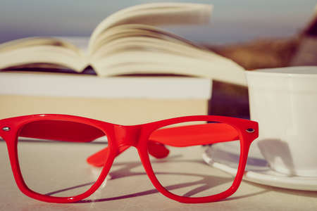 Reading on holidays. Coffee cup and book outdoors. Relaxation resting vacations concept.の写真素材