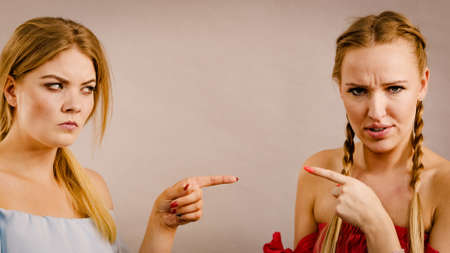 Women accusing each other of something, fighing having friendship problems, pointing and blaming.の写真素材