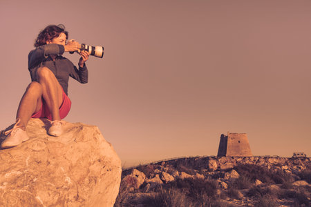Female tourist with camera taking travel photo from Mesa Roldan watchtower, Cabo de Gata Nijar...