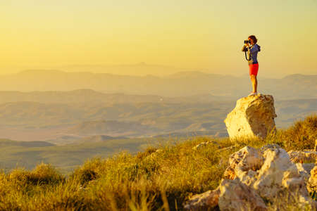 Tourist woman with camera taking travel photo from coastal spanish landscape, Mesa Roldan location in province Almeria, Andalusia Spain. Cabo de Gata Natural Park.の写真素材