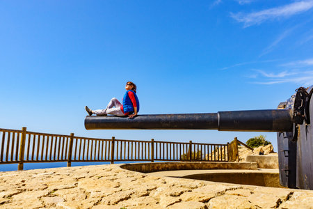 Tourist attraction. Woman at Battery de Castillitos in Spain Cartagena, Cabo Tinoso. Military cannon...