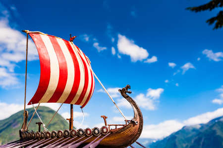 Old wooden viking longboat sails, drakkar boat on fjord shore in Norway. Tourism and traveling conceptの写真素材