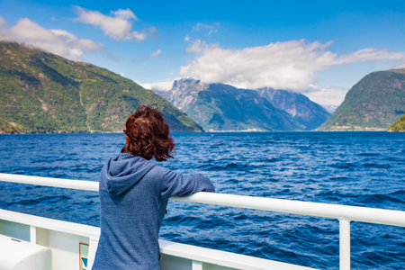 Tourism vacation and travel. Tourist woman on cruise ship enjoying fjord Sognefjord view in Norway,...