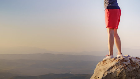 Tourist woman legs on rock viewpoint enjoying sunset landscape. Mesa Roldan location in province...