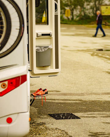 EIDFJORDEN, NORWAY- 25 JUNE 2018: ASICS running shoes at camper car. ASICS is Japanese company which produces footwear and sports equipment. Detail view open door with shoes.のeditorial素材